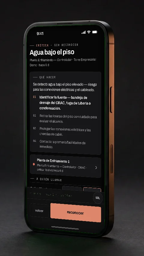 La app Vaultis en un teléfono: alarma «Agua bajo el piso» con su bloque «qué hacer» en cuatro pasos.